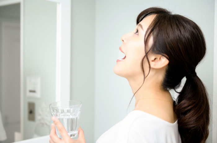 洗面所でうがいをする女性 口腔内を清潔に保つ習慣 歯科医院推奨ケア